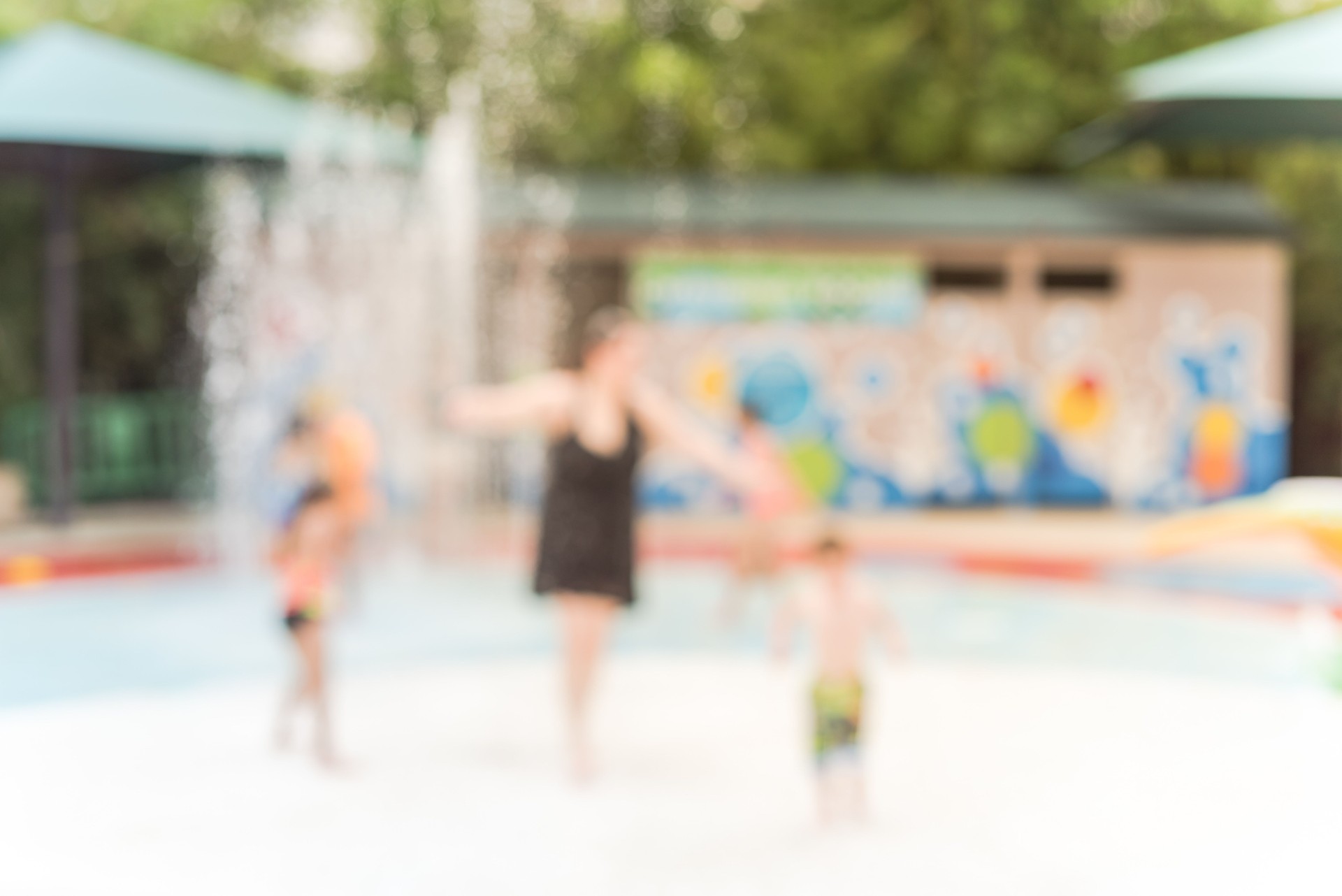 Blurry background diverse children playing at water splash pad in Houston, Texas